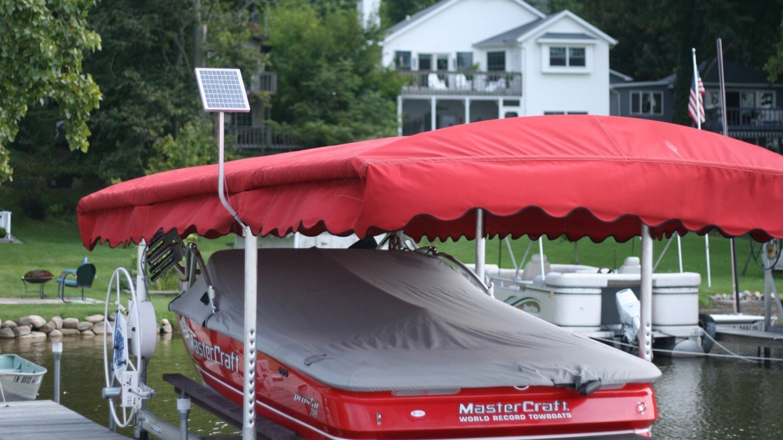mastercraft under red canopy with 12v solar charging kit for boat lift